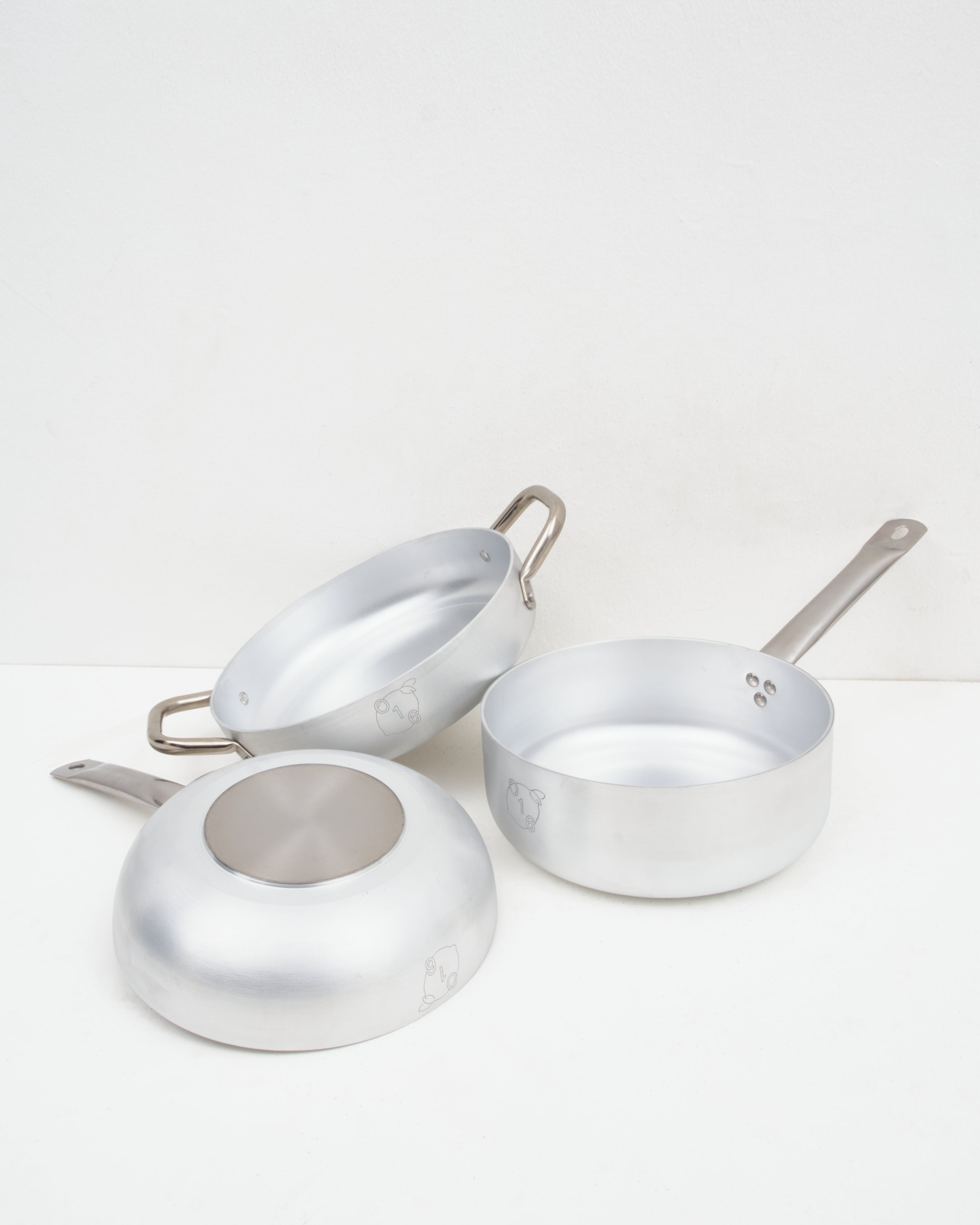 Studio: O16 mellemstort aluminiumskokkesaet fra Osteria 16 vist med indersider og bund — sammensat studiebillede på hvid | O16 medium aluminium cookware bundle by Osteria 16 shown with interiors and base — arranged studio shot on white