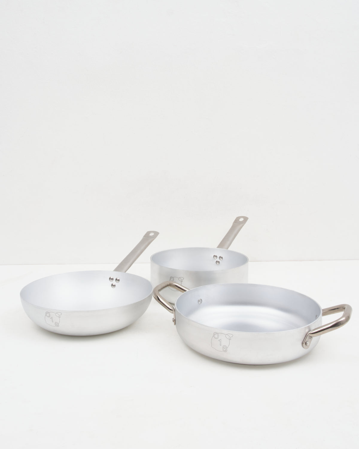 O16 mellemstort kokkesaet i aluminium med dyb stegepande, kasserolle og sauterpande fra Osteria 16 — samlet studiebillede | O16 medium cookware bundle in aluminium with deep frying pan, saucepan and saute pan by Osteria 16 — studio group shot