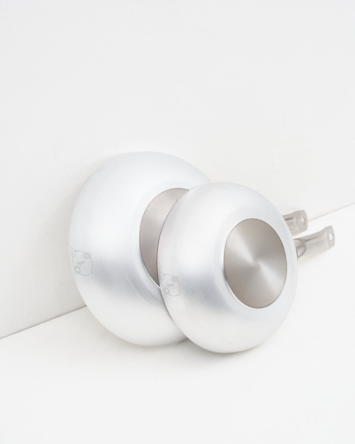 O16 Padella dybe stegepander i to størrelser i aluminium — stablet og set bagfra med logoer, Osteria 16 | O16 Padella deep frying pans in two sizes in aluminium — stacked and viewed from behind with logos, Osteria 16