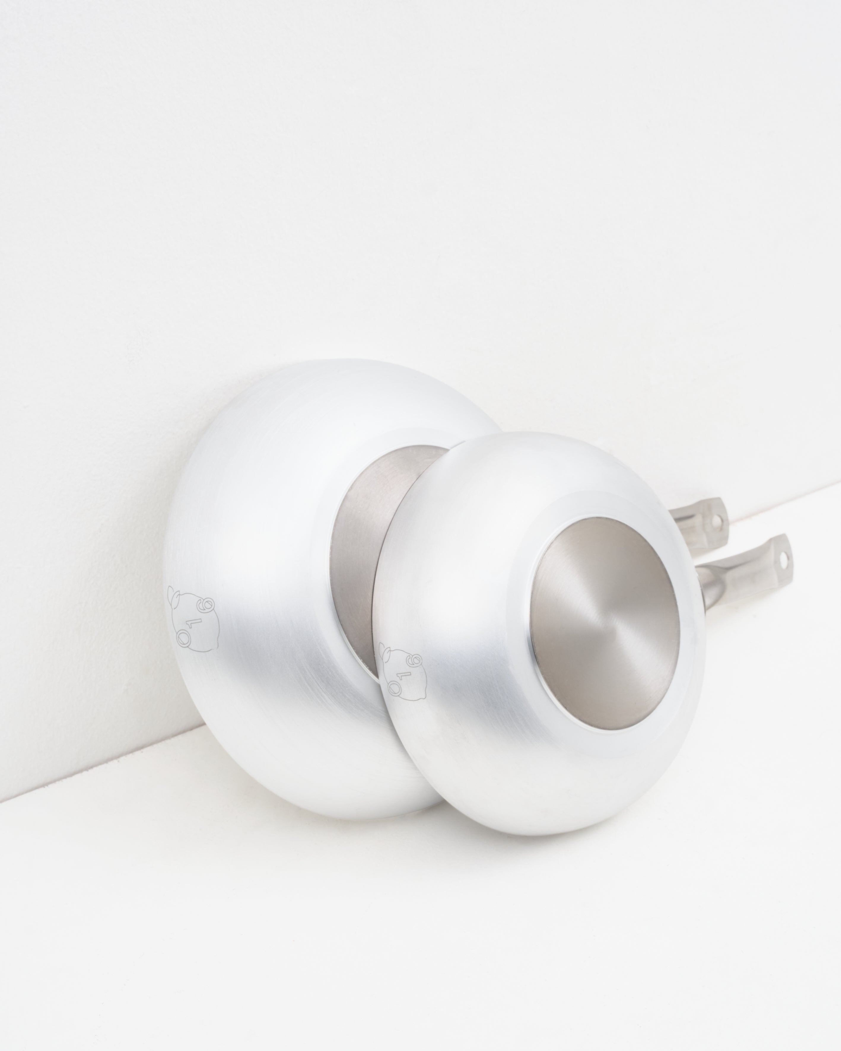 Studio: O16 Padella dybe stegepander i to størrelser i aluminium — stablet og set bagfra med logoer, Osteria 16 | O16 Padella deep frying pans in two sizes in aluminium — stacked and viewed from behind with logos, Osteria 16