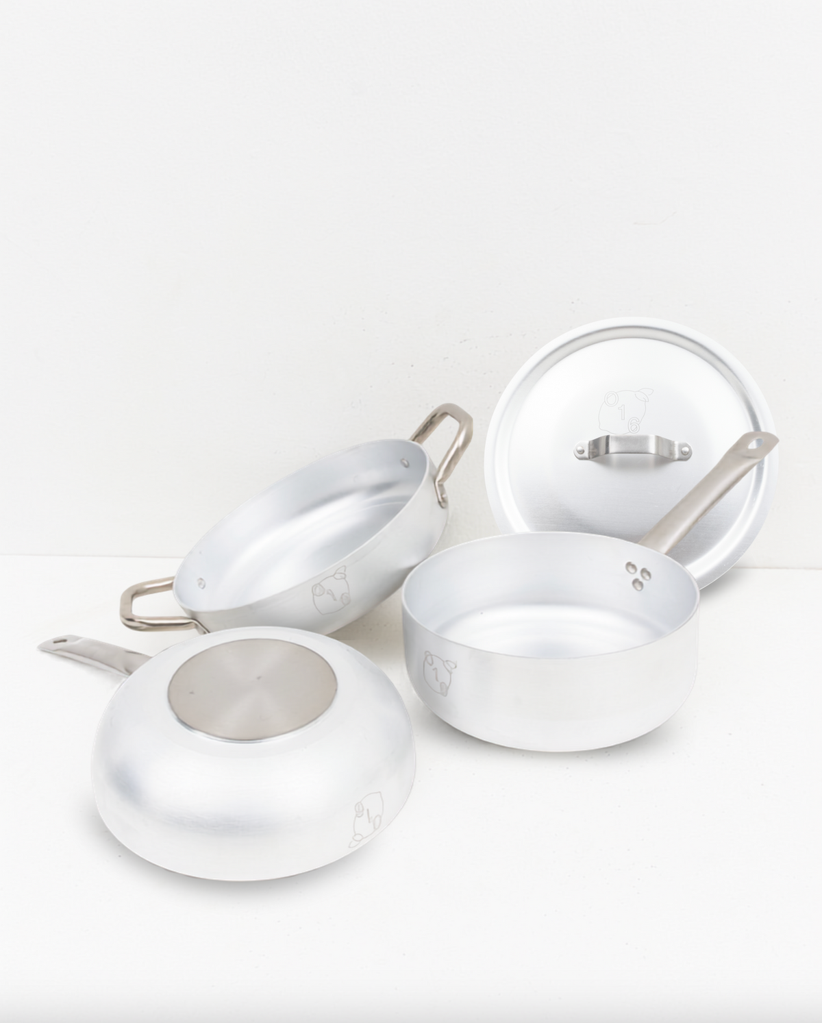 O16 aluminiums-kogegrej i studieopstilling — Padella sautépande, Casseruola kasserolle med låg og spunset aluminium på hvid baggrund | O16 aluminium cookware studio still life — Padella sauté pan, Casseruola saucepan with lid and spun aluminium on a white backdrop
