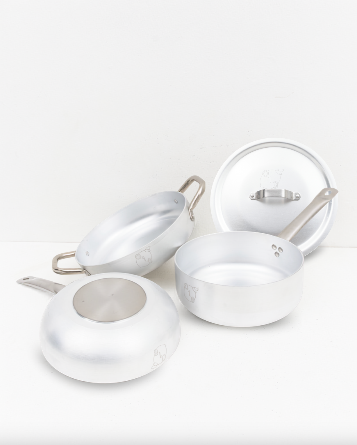Studio: O16 aluminiums-kogegrej i studieopstilling — Padella sautépande, Casseruola kasserolle med låg og spunset aluminium på hvid baggrund | O16 aluminium cookware studio still life — Padella sauté pan, Casseruola saucepan with lid and spun aluminium on a white backdrop