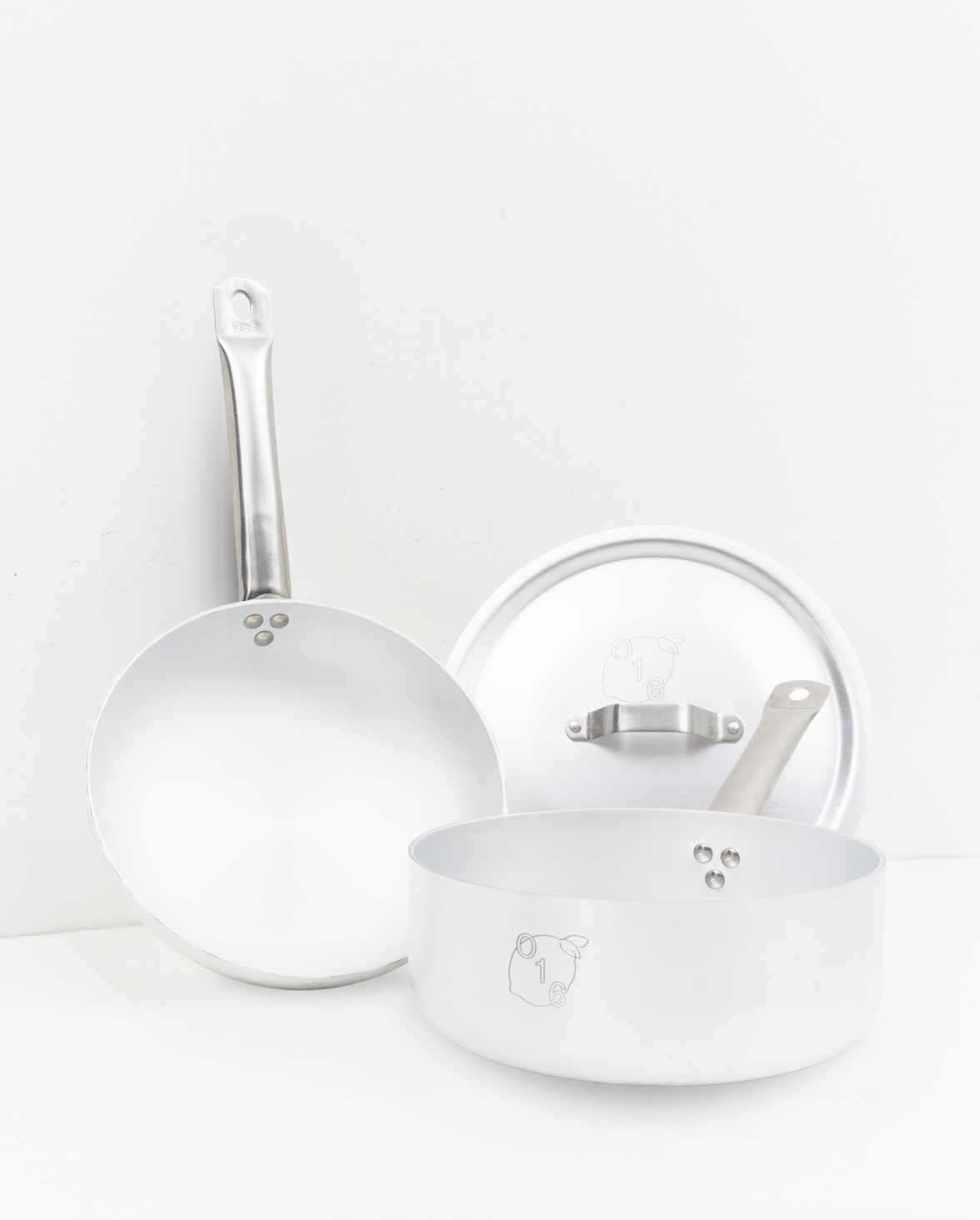 O16 Padella stegepande med langt håndtag og Casseruola kasserolle med låg, indgraveret O16-logo, studie på hvid | O16 Padella long-handled frying pan and Casseruola saucepan with lid, engraved O16 logo, studio shot on white