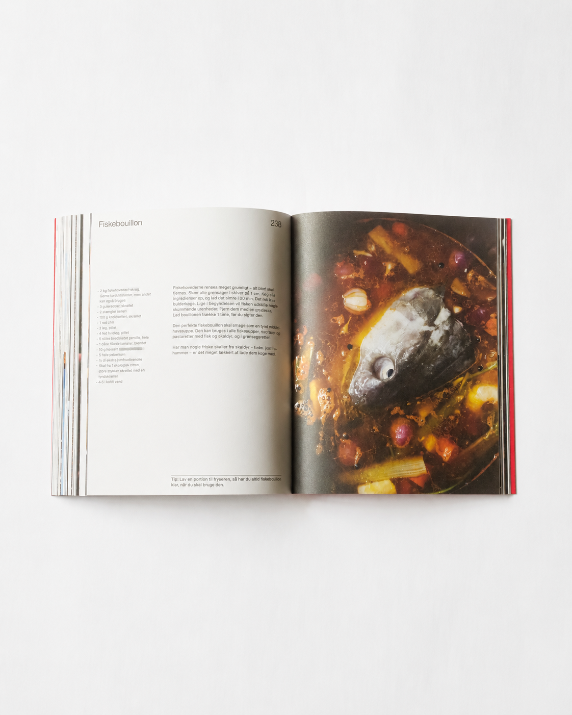 !Pages: O16 kogebog side 238 — fiskebouillon med fiskehoved og grøntsager i gryde, råt nærbillede | O16 cookbook page 238 — fish stock with a fish head and vegetables in a pot, raw close-up