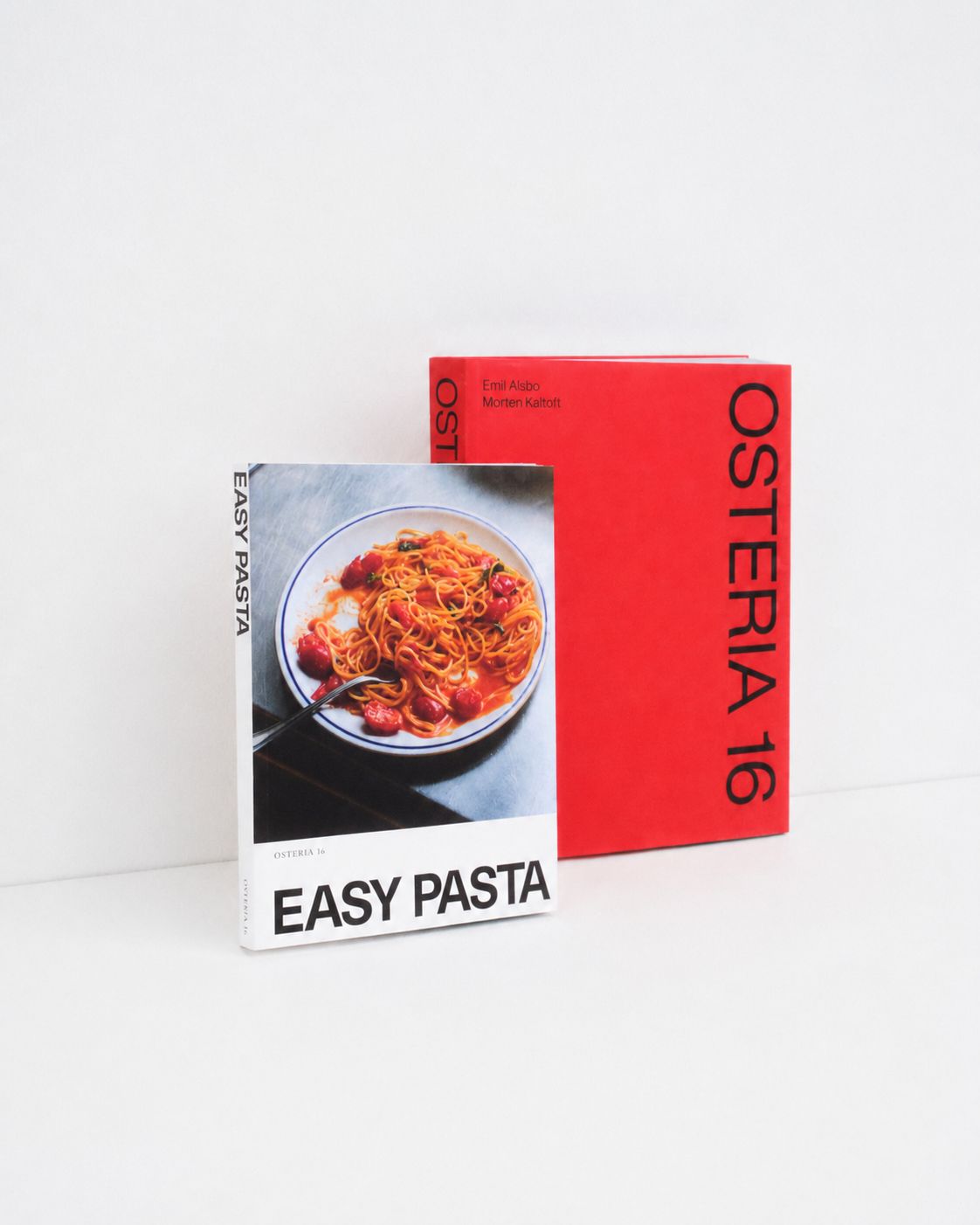 Osteria 16 "Easy Pasta" kogebog foran den røde Osteria 16 bog på hvid baggrund — studieoptagelse | Osteria 16 "Easy Pasta" cookbook in front of the red Osteria 16 book on white — studio shot