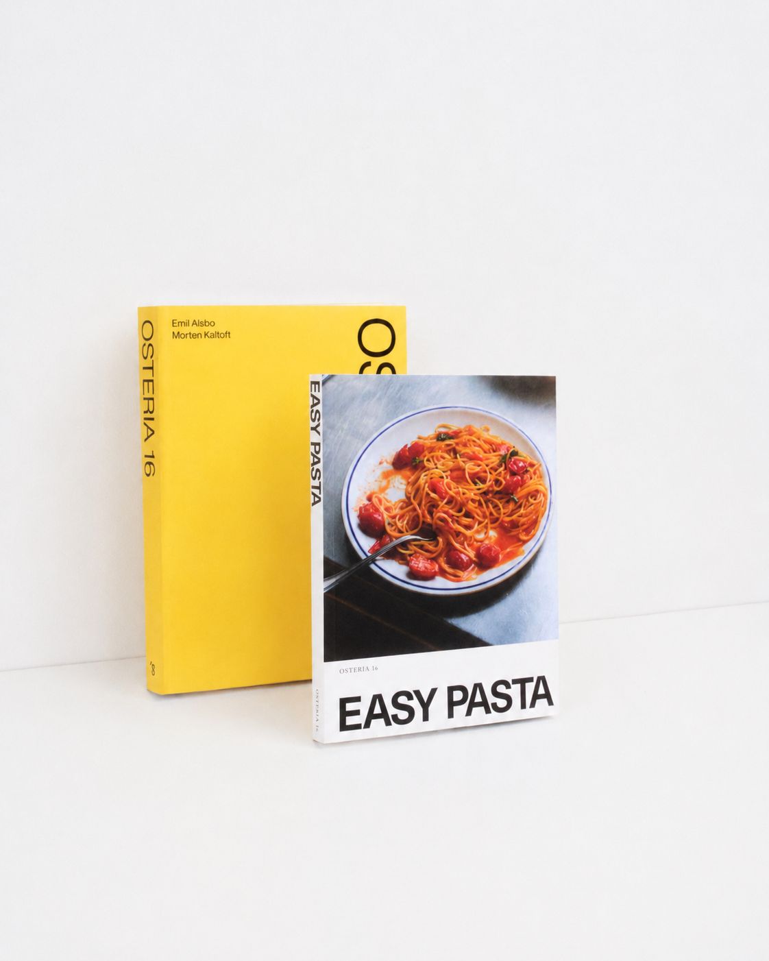 Studio: Osteria 16 "Easy Pasta" kogebog og gul Osteria 16 bog stående på hvid baggrund — studieoptagelse | Osteria 16 "Easy Pasta" cookbook and yellow Osteria 16 book standing on white — studio shot