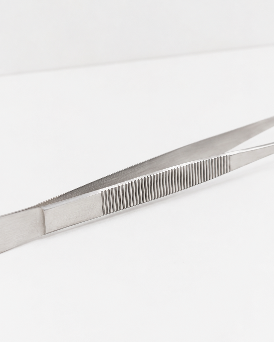 Detalje af O16 Pinze køkkentang i rustfrit stål med riflet greb, studieshot på hvid baggrund | Detail of the O16 Pinze stainless steel kitchen tongs with ridged grip, studio shot on a white background