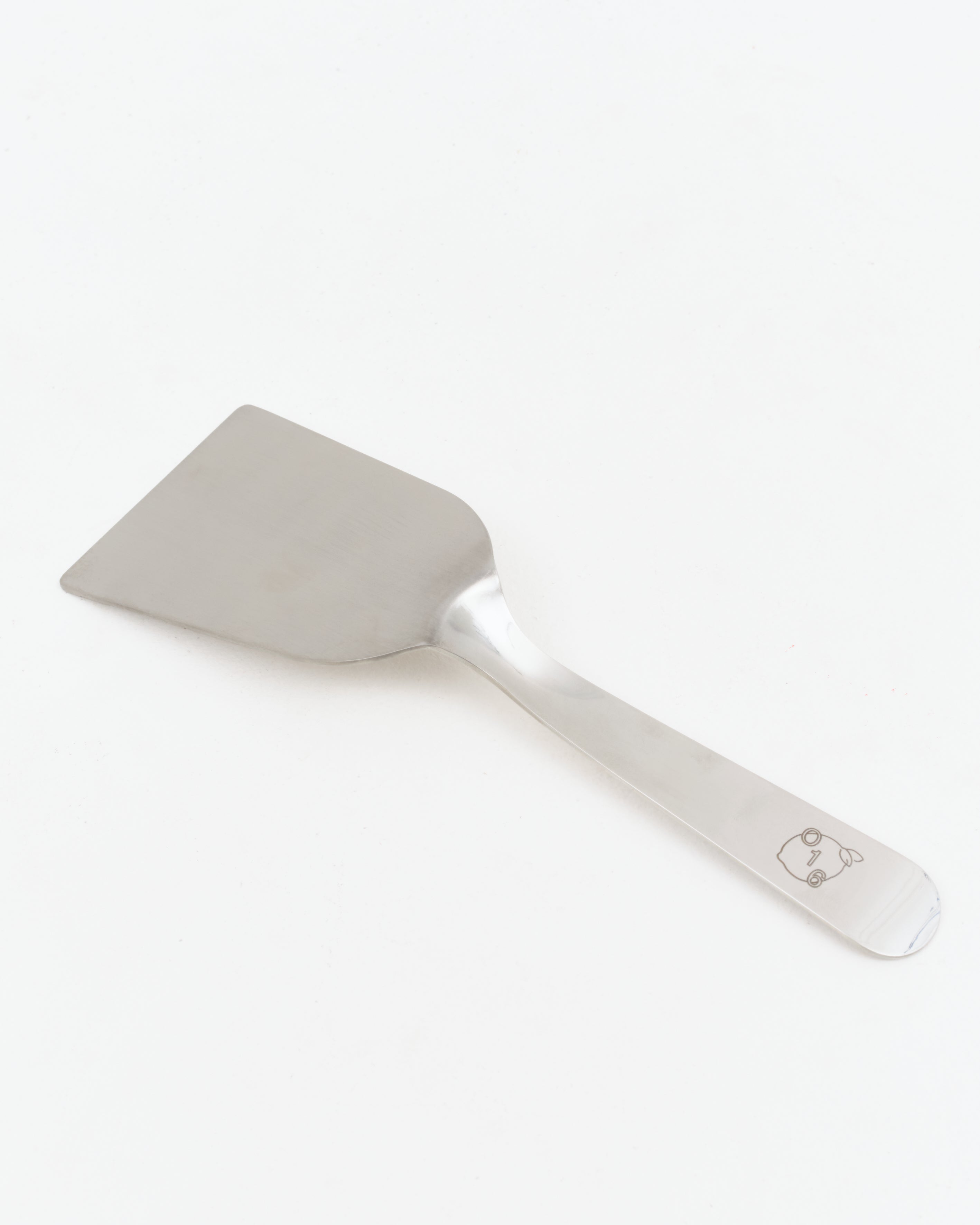 Studio: O16 Spartula vendespatel i rustfrit stål — vinklet studieoptagelse på hvid baggrund | Osteria 16 Spartula stainless steel turner spatula — angled studio shot on white
