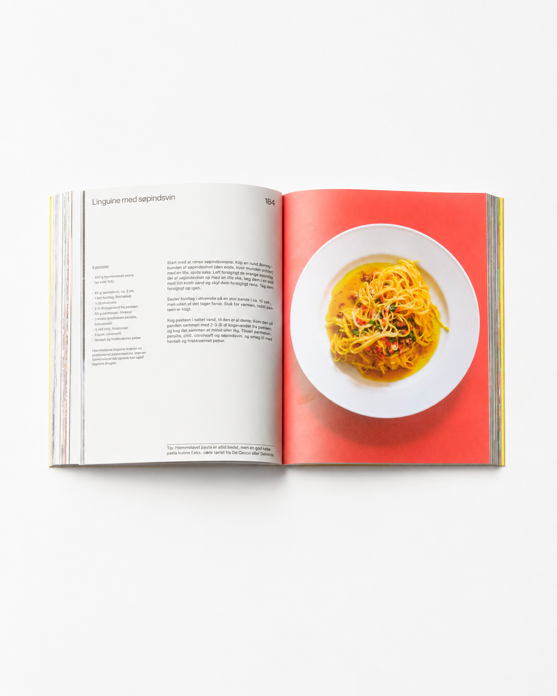 !Pages: Opslag i O16 kogebog med Linguine med søpindsvin-opskriften og foto af linguine på rød baggrund. | Spread in the O16 cookbook showing the Linguine with sea urchin recipe with a photo of linguine on a red background.