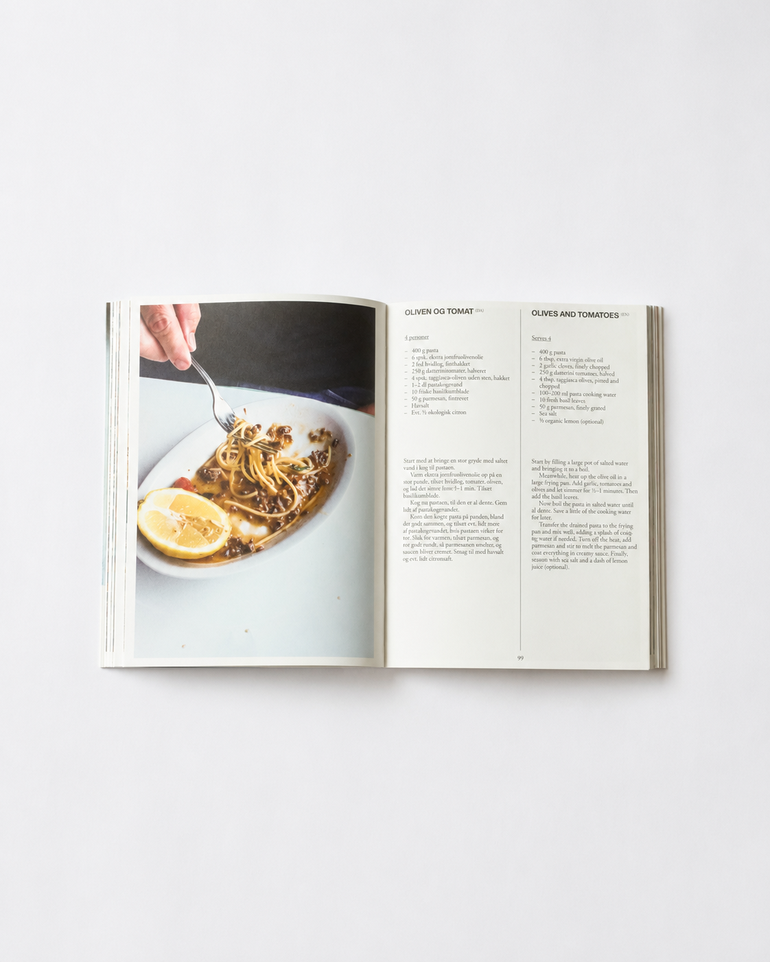 !Pages: Opslag i O16 kogebog med Oliven og tomat, Olives and Tomatoes, og foto af spaghetti med citron. | Spread in the O16 cookbook showing the Olives and Tomatoes recipe with a photo of spaghetti and lemon.