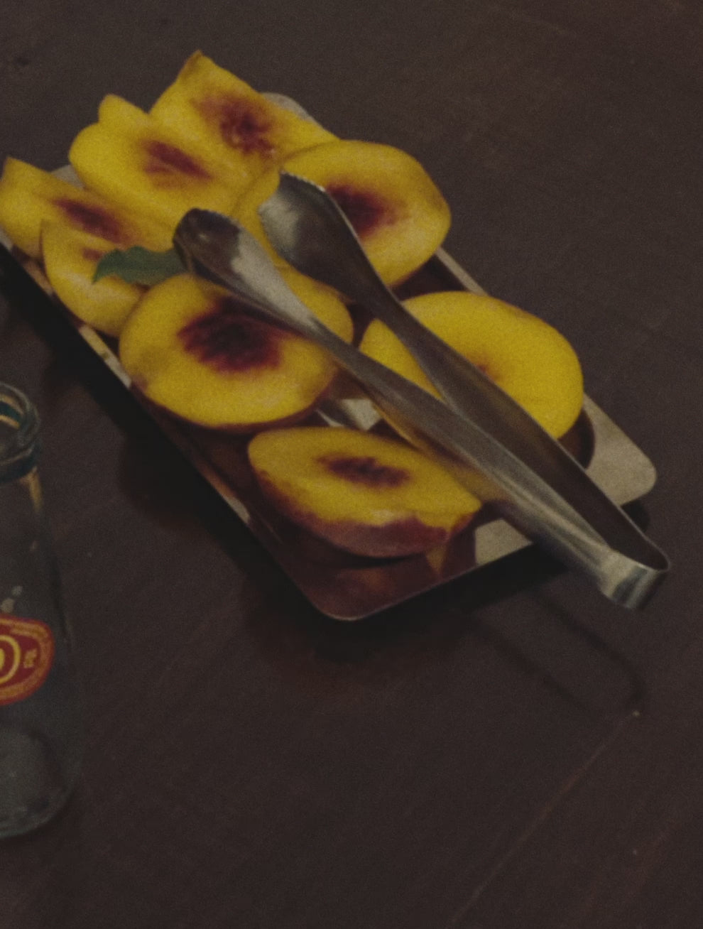 Motion: Videoklip fra Osteria 16 — en hånd anretter i bevægelse saftige tomatskiver i en O16-pande, fanget i blødt, rustikt filmet lys. | Osteria 16 motion clip — a hand plates juicy tomato slices into an O16 pan in motion, captured in soft, rustic analogue film light.